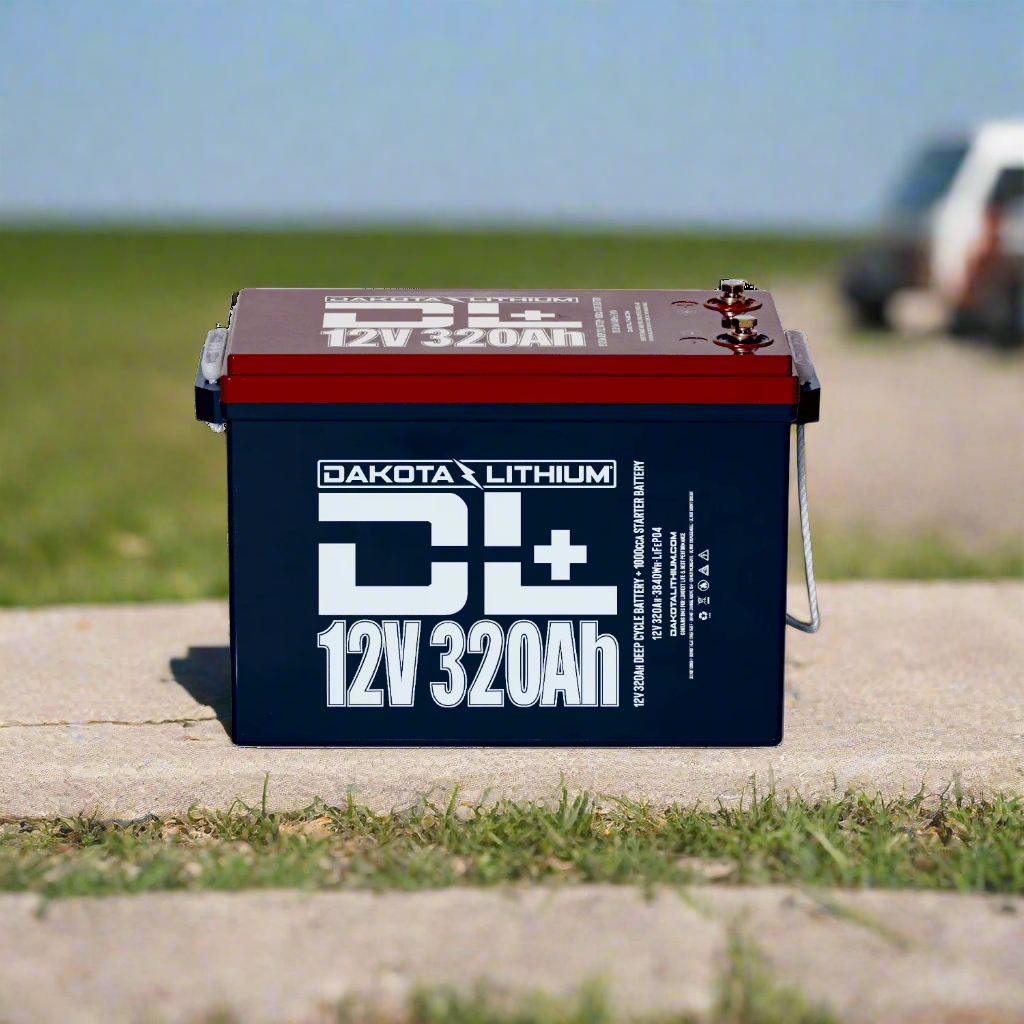 Dakota Lithium battery on a concrete surface with grass and a blurred vehicle in the background