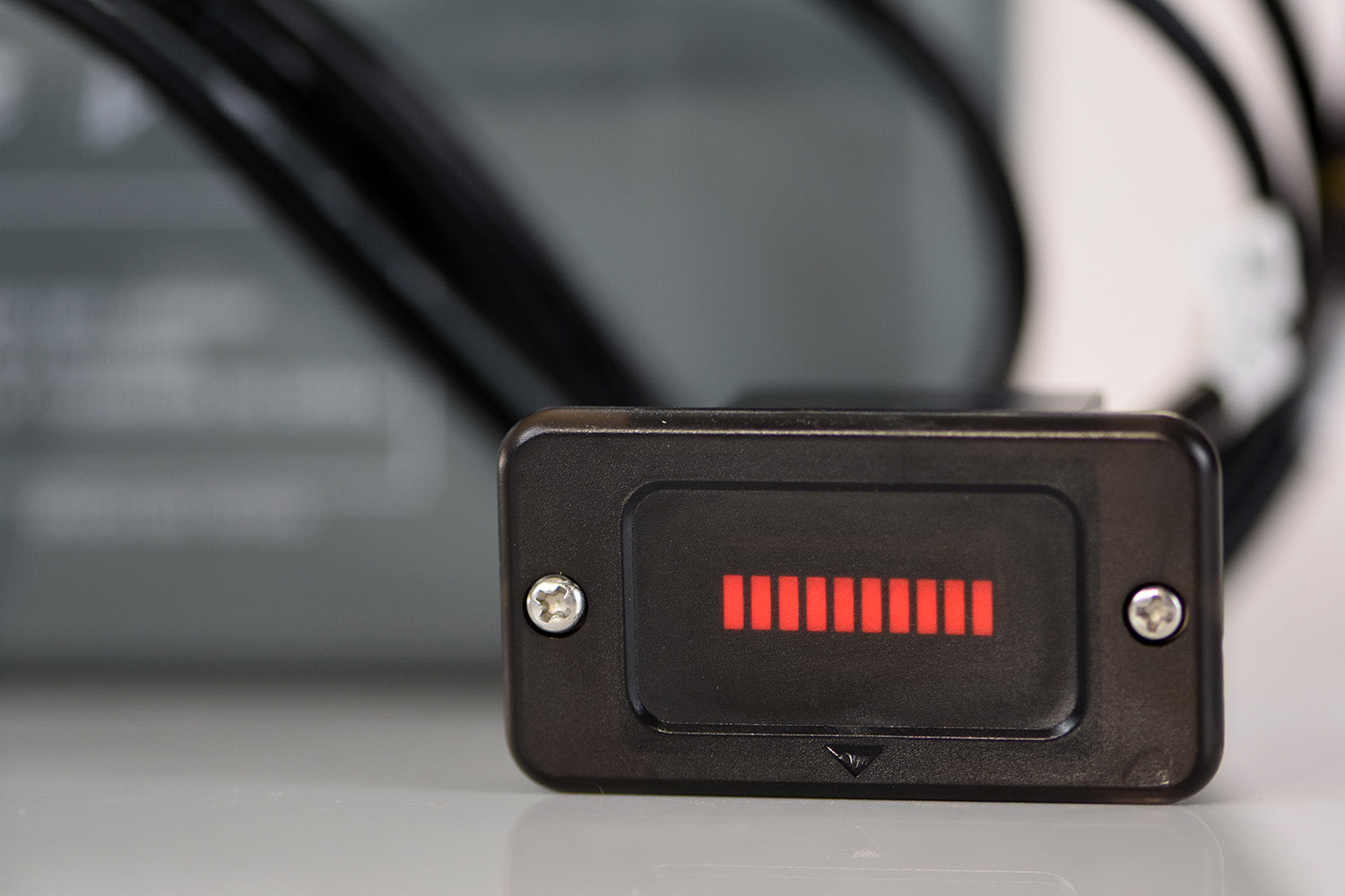 Black electronic device with red display on a blurred background
